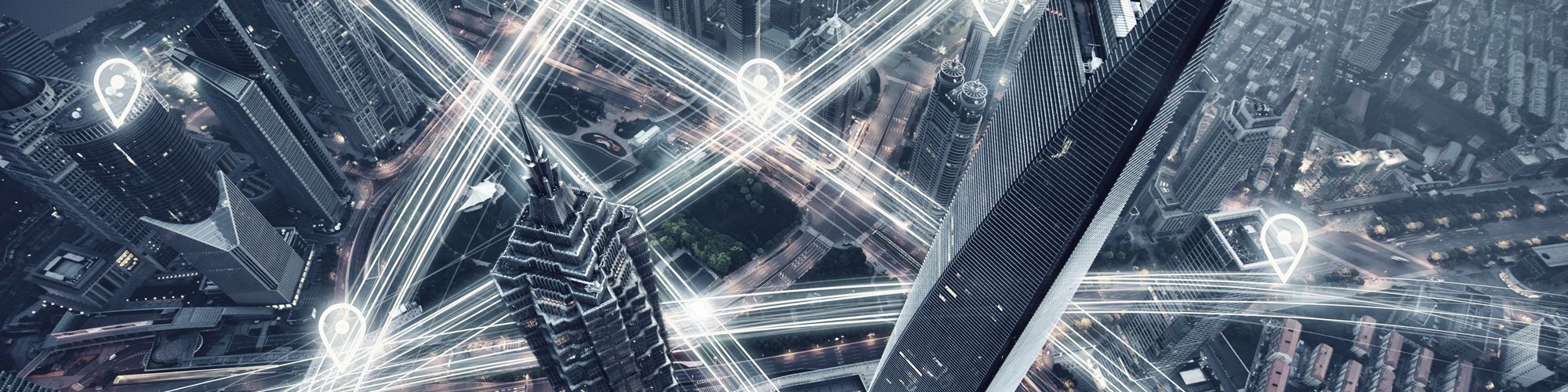 Eine Metropole von oben. Die Straßen sind umgeben von weißen Lichtstreifen.